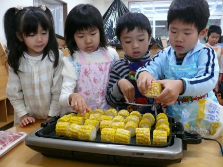 とうもろこしヤキヤキ、転がし係